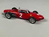 the model of a red race car is sitting on a white surface
