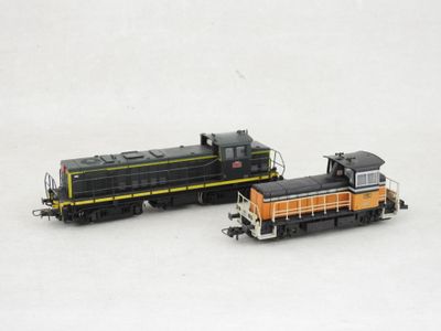 deux petits trains assis côte à côte sur une surface blanche