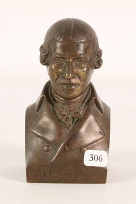 bronze bust of a man in a suit with a name tag on it