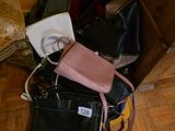 several purses are stacked on top of each other on a wooden floor