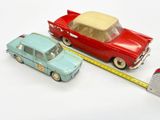 two toy cars that are next to a measuring tape