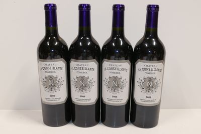 quatre bouteilles de vin sont alignées sur une table
