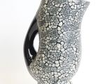 a black and white vase sitting on a white surface