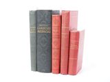 plusieurs vieux livres sont empilés sur une surface blanche