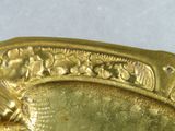 a close up of a gold plate with a bird on it