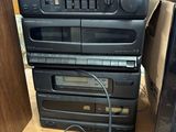 a stack of cassette players sitting on top of a wooden table