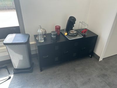 un meuble noir sur lequel est posée une cafetière