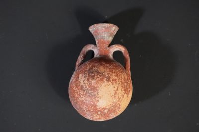 a small vase that is sitting on a black surface