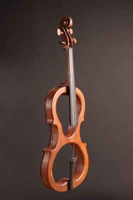un violon en bois posé sur un pupitre, sur fond noir