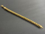 une photo d'un bracelet en or orné d'un motif tressé