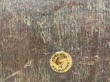 a wooden box that has a metal tag on it