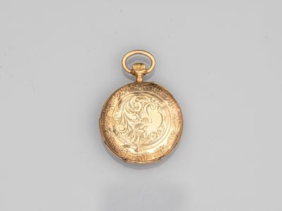 an old gold pocket watch with a chain hanging from it ' s side