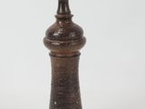 a small wooden pepper shaker on a white surface