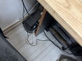 a wooden desk with a laptop and a cell phone on it