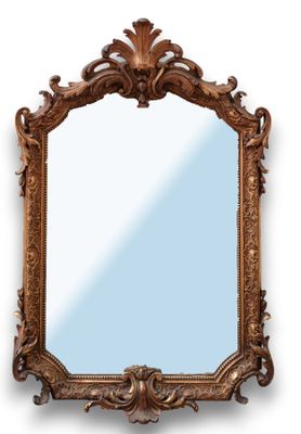 un miroir richement sculpté sur fond blanc, avec un ciel bleu en arrière-plan