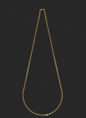 un collier en or composé d'une chaîne et d'une perle sur fond noir