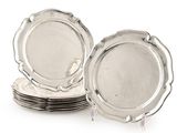 plusieurs assiettes en argent empilées les unes sur les autres sur une surface blanche