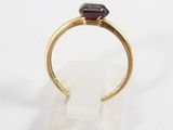 a close up of a gold ring with a garnet stone on it