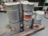 plusieurs seaux de peinture posés sur une palette dans un entrepôt