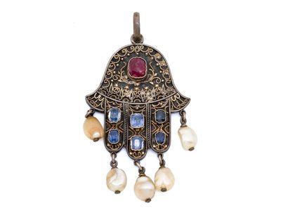 un gros plan sur un collier orné de perles et d'une hamsa