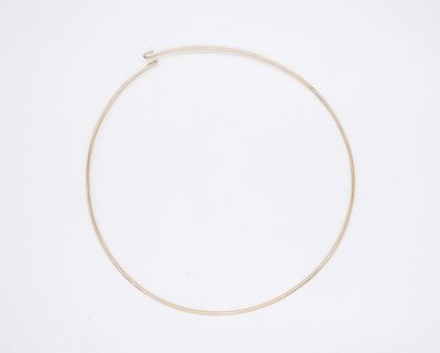un collier en or orné d'une seule perle sur fond blanc