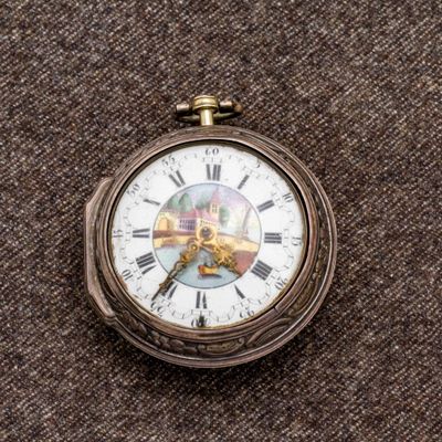 un gros plan d'une montre de poche ornée de chiffres romains