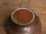 a brown vase sitting on the floor on the floor