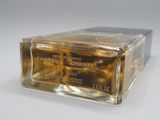 chanel gold perfume bottle on white surface with white background