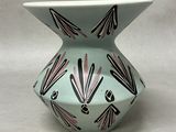 a white vase with a black and pink design on it