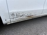 a white car that has a lot of dirt on the side of it