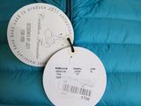 the back of a blue down jacket with a tag attached to it