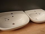 two white sinks sitting on top of a wooden counter
