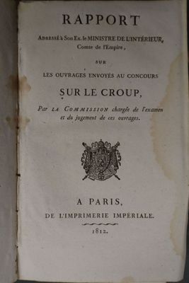 un vieux livre posé sur une table à côté d'un mur