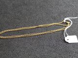a pair of gold chain earrings with a tag on them