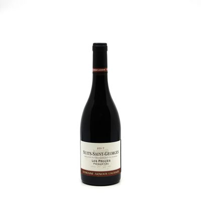 the bottle of wine is sitting on a white surface