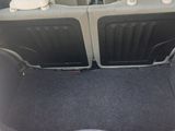 the back of a red car with its trunk open and seats folded down
