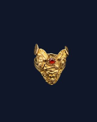 an image of a gold ring with a red stone in the center