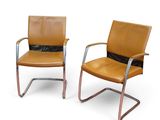deux chaises en cuir marron assises l'une à côté de l'autre sur une surface blanche