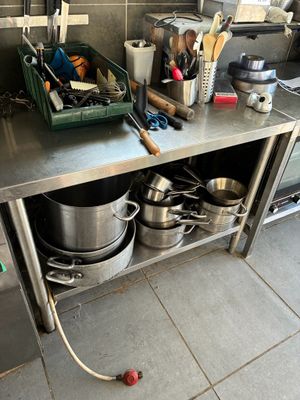 a kitchen with many pots and pans on the counter