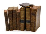 plusieurs vieux livres sont empilés sur une surface blanche