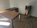 a desk and a chair in the corner of a room