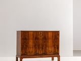 une photo d'une commode en bois dans une pièce blanche