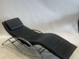 black leather chaise lounger and ottoman in the shape of a reclining chair