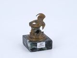 une statue en bronze représentant un oiseau, posée sur un socle en marbre