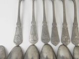 six spoons are lined up in a row on a white surface