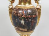 un vase en or orné d'une peinture, posé sur une table