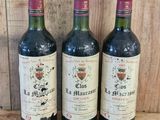 three bottles of wine sitting on top of a wooden table