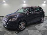 un SUV noir garé sur un sol en carrelage à damier dans un garage