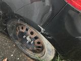 a black car that has been damaged and is parked on the side of the road