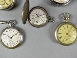 many different types of pocket watches displayed on the table
